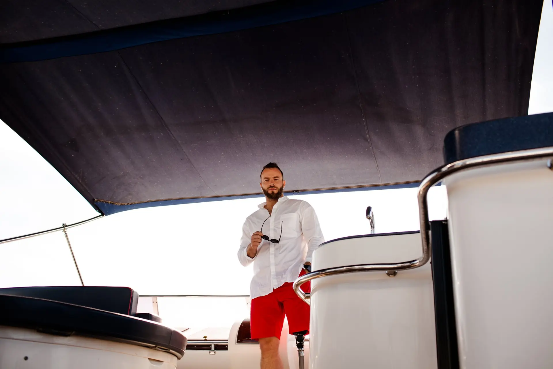 Mulher de chapéu sentada na proa de um barco, com prótese de perna